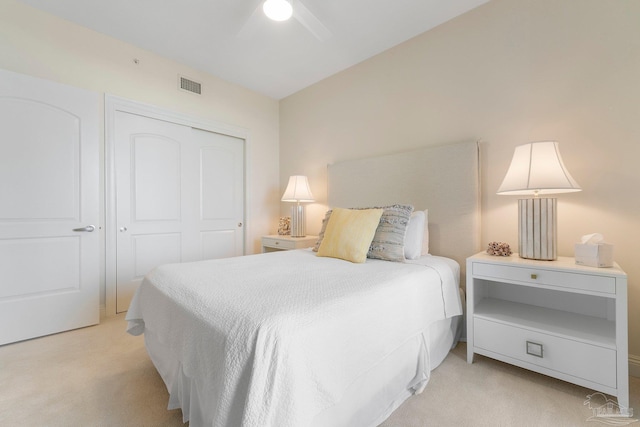 bedroom featuring light colored carpet, a closet, and ceiling fan