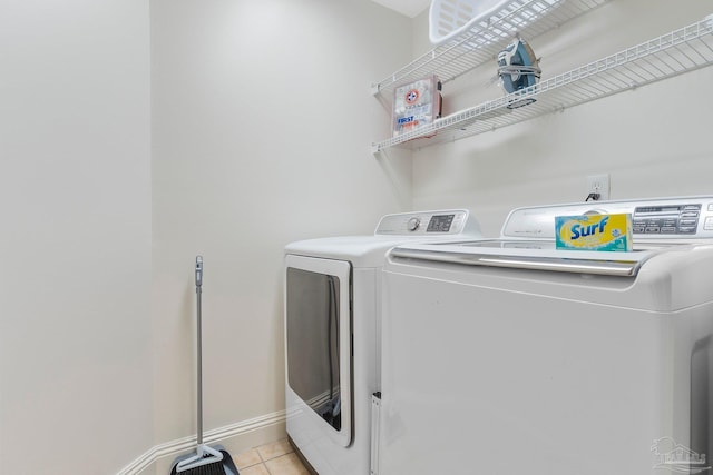 clothes washing area with light tile patterned floors and separate washer and dryer