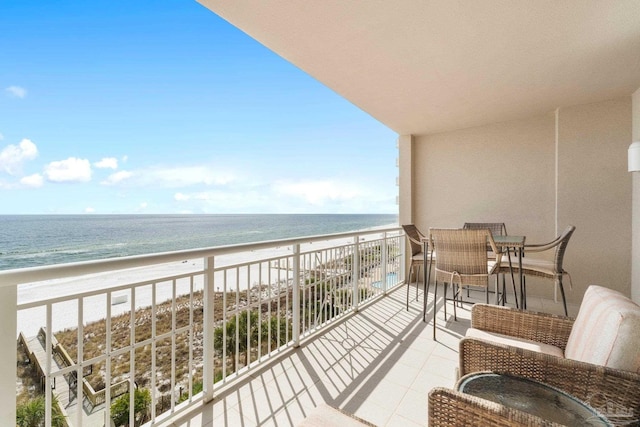 balcony featuring a water view and a beach view