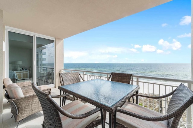 balcony featuring a view of the beach and a water view