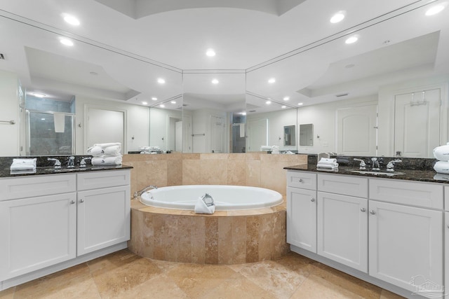 bathroom featuring vanity, separate shower and tub, and a raised ceiling