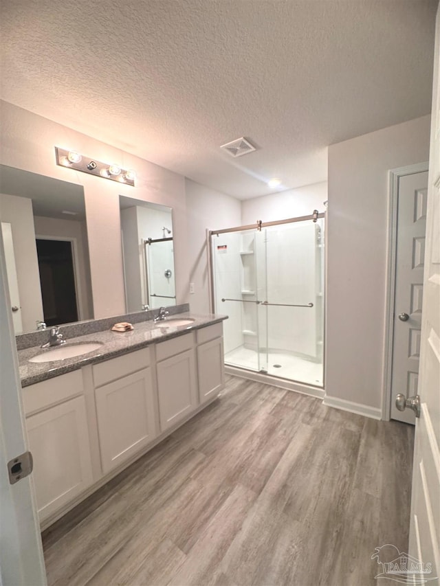 3468 Fallschase Blvd, Pensacola, FL 32526 - full bath with wood finished floors, a shower stall, double vanity, and a textured ceiling