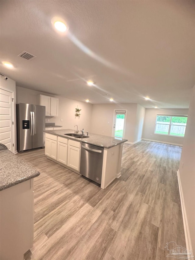 3468 Fallschase Blvd, Pensacola, FL 32526 - kitchen with appliances with stainless steel finishes, white cabinetry, a center island with sink, a sink, and light wood-type flooring