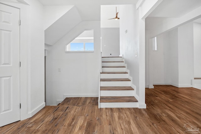 staircase with vaulted ceiling and hardwood / wood-style flooring