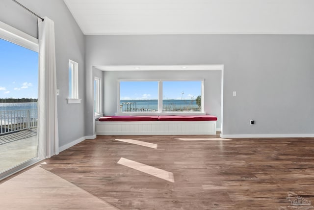 spare room with hardwood / wood-style floors and a water view