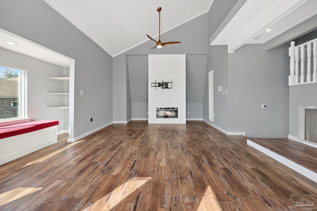 unfurnished living room featuring a large fireplace, heating unit, ceiling fan, wood-type flooring, and high vaulted ceiling