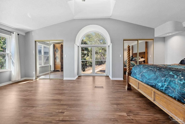 bedroom featuring dark hardwood / wood-style floors, access to exterior, lofted ceiling, and a textured ceiling