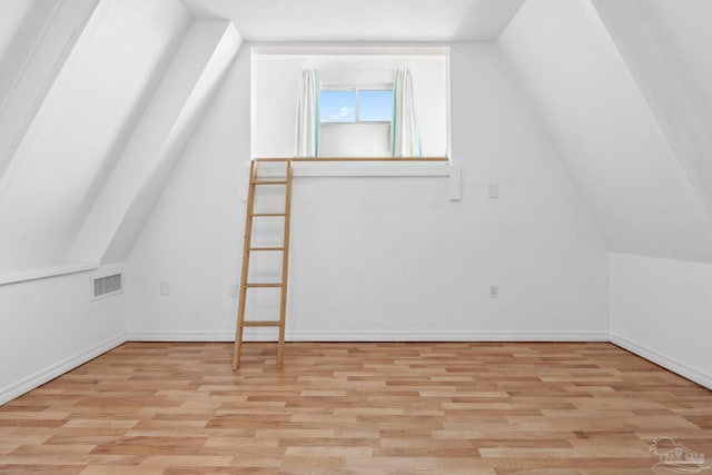 bonus room with light hardwood / wood-style floors and lofted ceiling