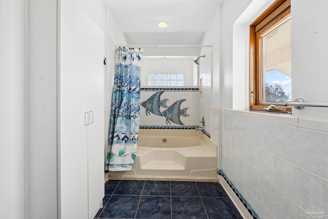 bathroom featuring tile patterned floors, plus walk in shower, and tile walls