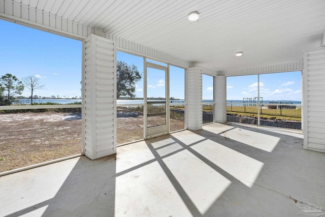 unfurnished sunroom with a water view