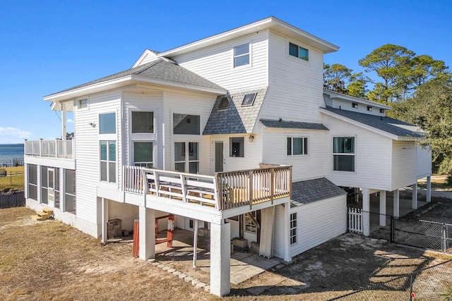 rear view of house featuring a deck with water view