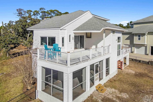 back of property with a balcony and a sunroom