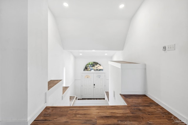 foyer entrance with dark hardwood / wood-style flooring and vaulted ceiling