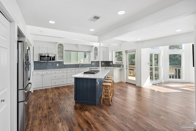 kitchen featuring a center island, dark wood-type flooring, white cabinets, sink, and stainless steel appliances