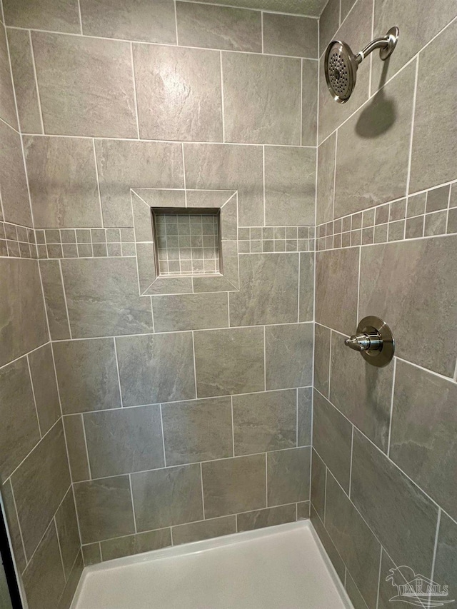 bathroom with a tile shower