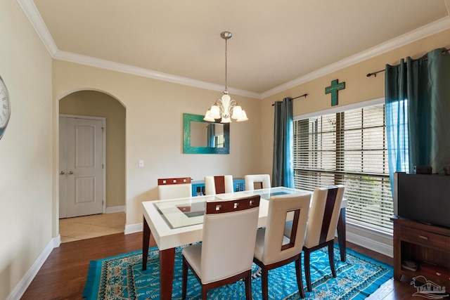 dining area with dark hardwood / wood-style flooring, crown molding, and a chandelier