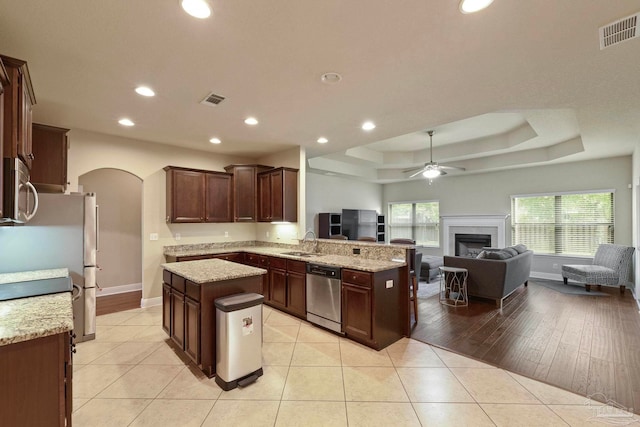 kitchen featuring a center island, sink, light hardwood / wood-style floors, kitchen peninsula, and stainless steel appliances