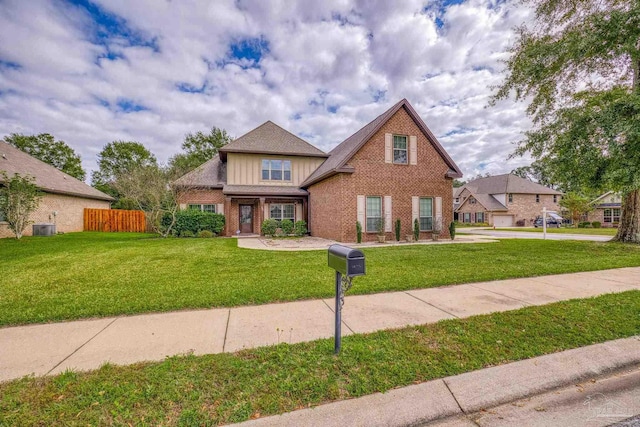 view of front of house with central AC and a front yard