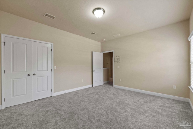 unfurnished bedroom featuring carpet and a closet