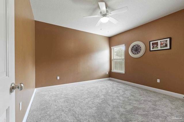 carpeted empty room with ceiling fan and a textured ceiling