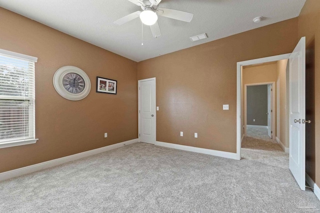 carpeted spare room with ceiling fan