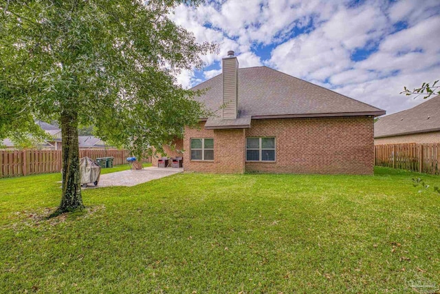 rear view of house with a patio area and a lawn