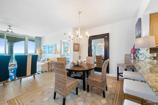 dining space with an inviting chandelier, light tile patterned floors, baseboards, and a textured ceiling