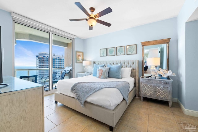 bedroom featuring ceiling fan, baseboards, expansive windows, light tile patterned floors, and access to outside