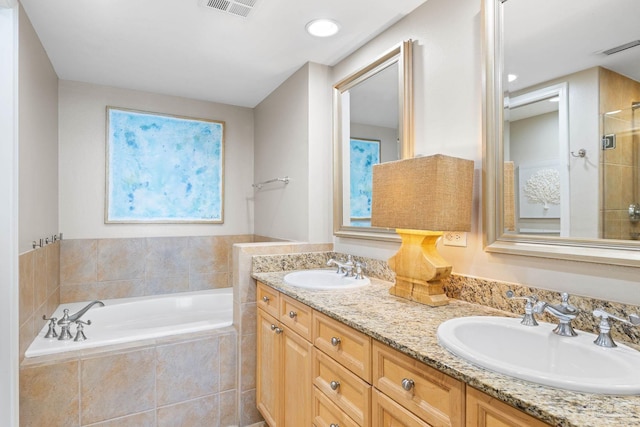 full bath with double vanity, a bath, visible vents, and a sink