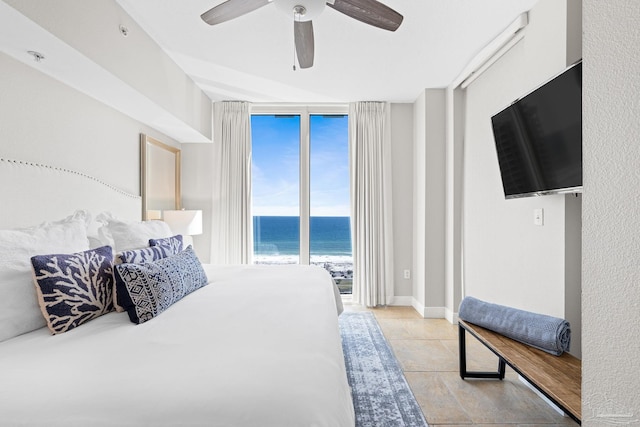 bedroom with access to exterior, light tile patterned floors, a wall of windows, and ceiling fan