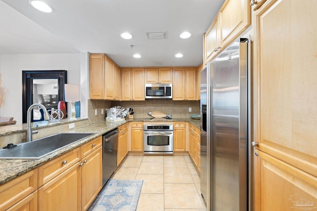 kitchen featuring light brown cabinets, visible vents, a sink, appliances with stainless steel finishes, and backsplash