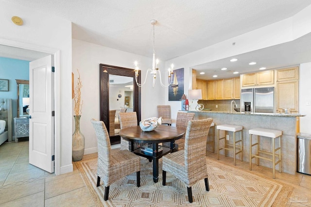dining area featuring a chandelier, light tile patterned floors, and baseboards