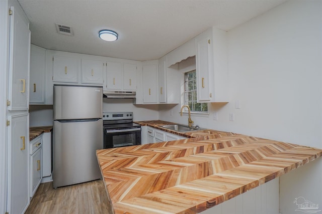 kitchen featuring a textured ceiling, stainless steel appliances, sink, light hardwood / wood-style flooring, and white cabinetry