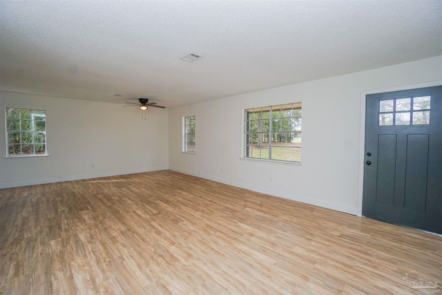 foyer entrance featuring ceiling fan, light hardwood / wood-style flooring, and a textured ceiling