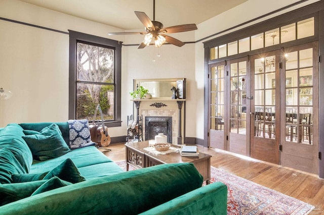 living room with baseboards, french doors, wood finished floors, and a high end fireplace