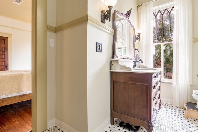 bathroom featuring ensuite bath, visible vents, baseboards, and vanity