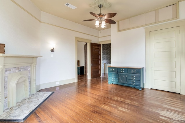 unfurnished living room featuring a fireplace, visible vents, light wood-style floors, a ceiling fan, and baseboards