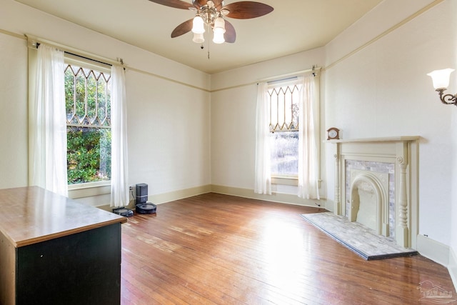 unfurnished living room featuring a wealth of natural light, a premium fireplace, and hardwood / wood-style flooring