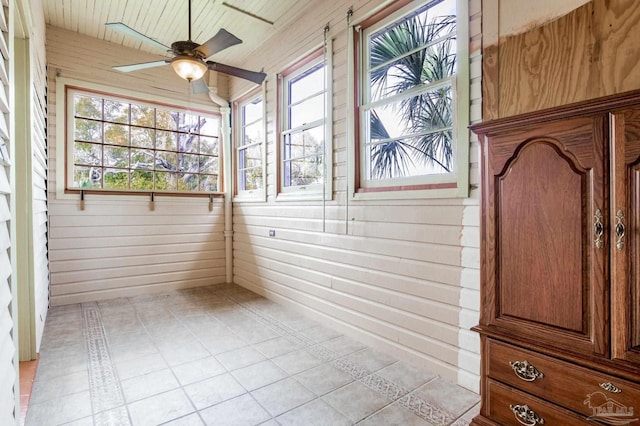 unfurnished sunroom featuring ceiling fan