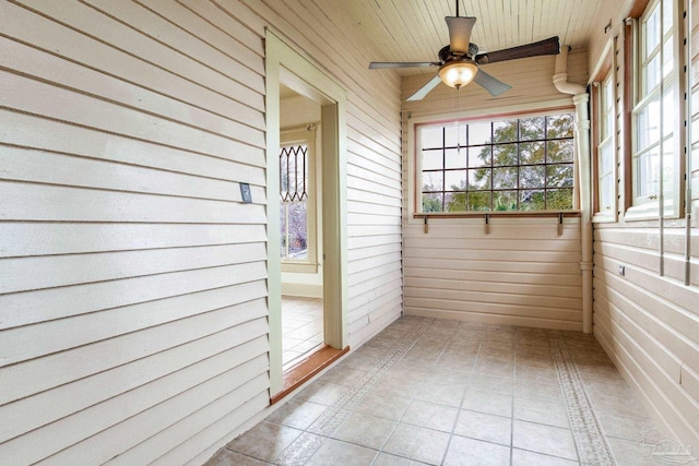 unfurnished sunroom featuring ceiling fan