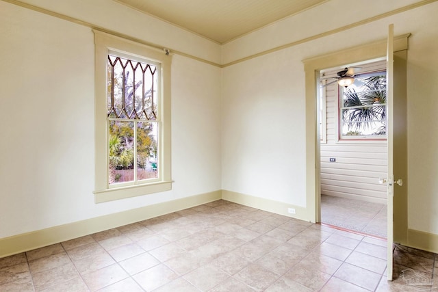 empty room with ceiling fan and baseboards