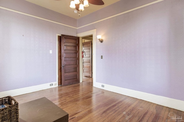 unfurnished room with a ceiling fan, baseboards, and wood finished floors