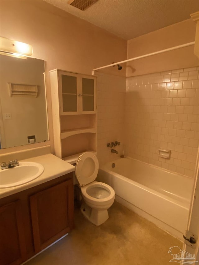 full bathroom with toilet, vanity, a textured ceiling, and tiled shower / bath