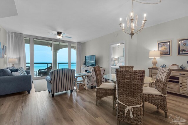 dining space featuring ceiling fan with notable chandelier and hardwood / wood-style flooring