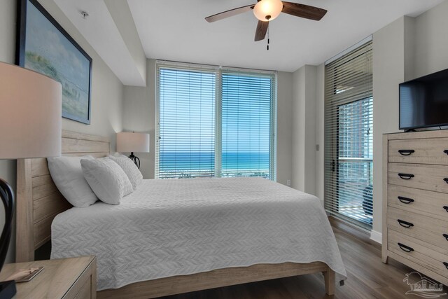 bedroom featuring ceiling fan, multiple windows, hardwood / wood-style flooring, and access to outside