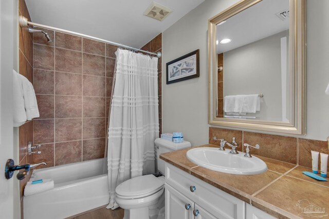 full bathroom with shower / tub combo with curtain, toilet, and vanity