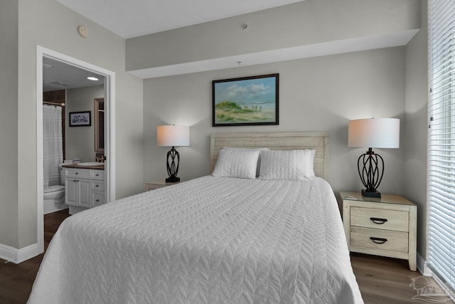 bedroom featuring dark hardwood / wood-style flooring, ensuite bath, and multiple windows