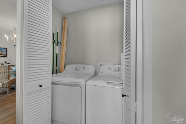 washroom featuring washing machine and dryer and light hardwood / wood-style flooring