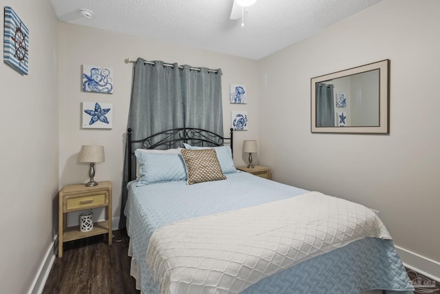 bedroom with ceiling fan, dark hardwood / wood-style floors, and a textured ceiling