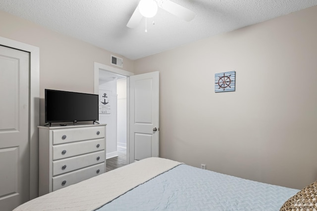 bedroom featuring hardwood / wood-style flooring, ceiling fan, and a textured ceiling